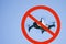 No-fly zone. Quadcopter drone flying in nature against the blue sky. Enclosed in red prohibition sign.