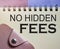 No hidden fees words on copybook page and pink wallet. Financial concept