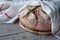 No knead handmade loaf on cutting board on rustic wood with linen towel, spelt ears. German Bauernbrot means Farmers