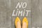 No limit text on gray sidewalk with woman legs, top view