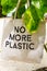 No More Plastic eco bag on branch of green tropical plant , vertical composition