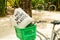 No More Plastic eco bag on green bicycle basket, parked on sandy tropical forest