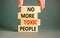 No more toxic people symbol. Concept words No more toxic people on wooden blocks on a beautiful grey table grey background.