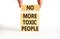 No more toxic people symbol. Concept words No more toxic people on wooden blocks on a beautiful white table white background.