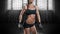 No name portrait of a strong muscular woman posing in the gym with dumbbells in her hands. The concept of shaping, bodybuilding,