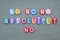 No, no, no, absolutely no, negative text composed with multi colored stone letters over green sand