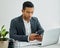 No quitting, no backing down. a businessman using a smartphone at his desk in a modern office.