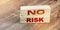 No Risk words on wooden blocks on wooden table. Risk management concept