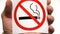 No smoking allowed sign isolated. Male hand holding no smoking sign