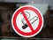 No smoking sign sticker on glass with out of focus public institution