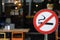 No smoking signpost infornt of a restaurant, piblic outdoor area