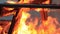 No sound. Extreme close-up video of a burning picnic table at the end of a party by a body of water.