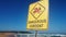 A no swimming (dangerous current) sign on beach