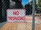 No trespassing sign behind fence wire in front of urban construction