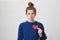 Nobody loves me. Portrait of upset cute redhead european woman with bun holding paper heart near chest and being