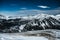 Nocky mountains in Alps photographed from a slope in February. Mountains full of trees partly covered in snow.