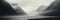 A noir panoramic view of hills and a lake with mist