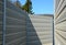 Noise barrier made of metal perforated sheet metal slats. gray and silver protective fencing separates housing from a busy noisy r