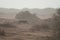 Nolan warthog trotting in a desert landscape.