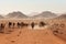 nomadic tribe with their herd of camels crossing the desert