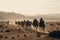 nomadic tribe with their herd of camels crossing the desert