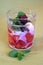 Non-alcohol fruit cocktail with strawberry and blackberry in yogurt with mint in the transparent glass on green background front v