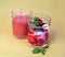 Non-alcohol fruit cocktails with strawberry and blackberry in yogurt with mint in the transparent glasses on green background fron