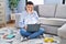 Non binary person studying using computer laptop sitting on the floor with hand on head for pain in head because stress