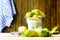 Noni fruit in zinc bucket and noni on table and old wooden background.