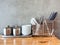 Noodle eating set, white spoons, black chopsticks, stainless steel containers, stack of white sauce bows on clean wooden table on