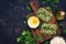 Noodle nests with spinach on dark fashioned rustic background. Flat lay, top view.