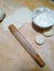 Noodle stick and dumpling skin on chopping board.