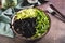 Noodles with cuttlefish ink, cucumber and arugula on a plate on the table