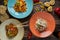 Noodles, fettuccine and penne pasta on three separate plates on a wooden background