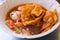 Noodles with fishballs and crispy wonton in red sauce