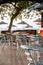 Nook of street cafee with several metal chairs and tables near sea.