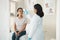 Nope, no fever. a young woman sitting in the clinic and getting her temperature checked by her doctor during a