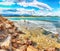 The Nora bay and beach, the medieval Sant\\\'Efisio church near the shore and mountains in the background