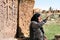 Noratus, Armenia-May, 01 2019: unique cemetery of khachkars. Old Armenian woman talk about khachkars.