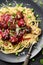 Nordic style meal. Linguine pasta and homemade meatballs with green peas, lingonberry sauce and cheese on grey plate on black