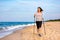 Nordic walking - beautiful woman exercising on beach