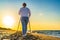 Nordic walking - beautiful woman exercising on beach at sunset