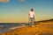 Nordic walking - beautiful woman exercising on beach at sunset