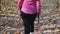 Nordic walking concept. Chubby woman with nordic walking poles training in autumn forest or park. Weight loss concept