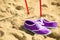 Nordic walking. sticks and violet shoes on a sandy beach