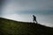 Nordic walking uphill on a hilly meadow in silhouette