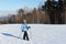 Nordic Walking - woman in a blue jacket hiking on snow