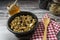 Normal view of a bowl with served granola and honey on a wooden table with a spoon. Healthy and natural eating concept