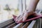 Normal view of a woman`s hands sanding a window frame before painting. Empowered woman concept