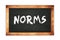 NORMS text written on wooden frame school blackboard